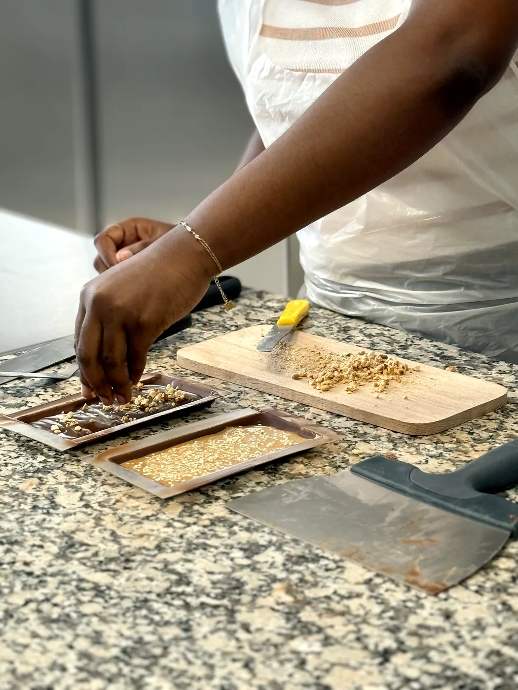 Ajout d'éclats de noisette sur une tablette de chocolat
