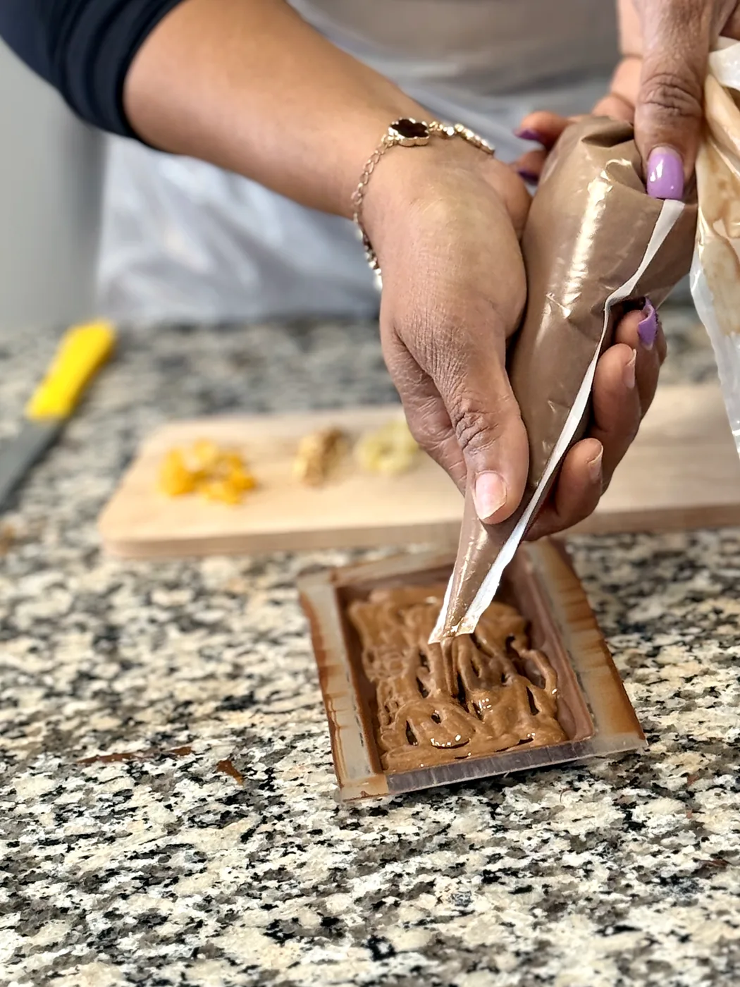 Bénédicte pochant du chocolat dans un moule à tablette, lors d'un atelier découverte