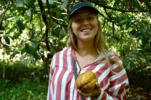 Bénédicte tenant une cabosse de cacao fraîchement récoltée, lors de son voyage au Pérou