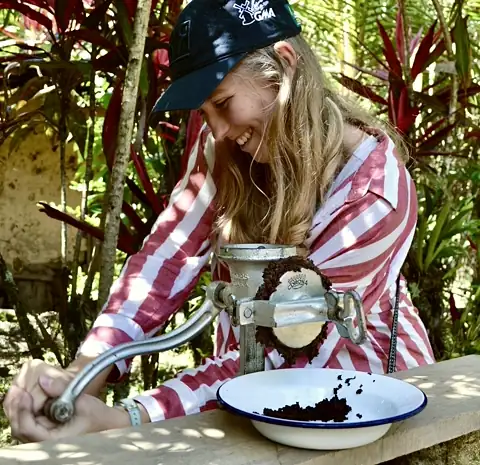 Bénédicte broyant des fèves de cacao au moulin traditionnel, au Pérou